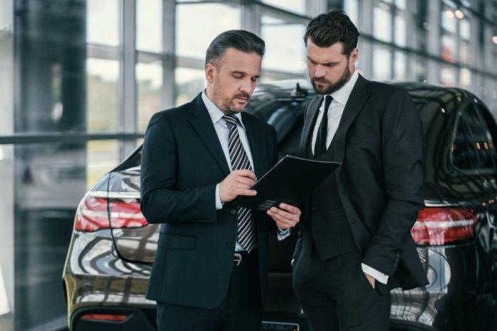top sales manager and customer at dealership PQZL8UE